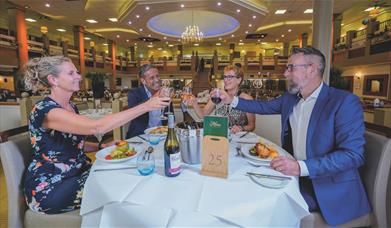 Two couples enjoy dinner together in the Garden Restaurant at Potters Resorts Hopton-on-Sea