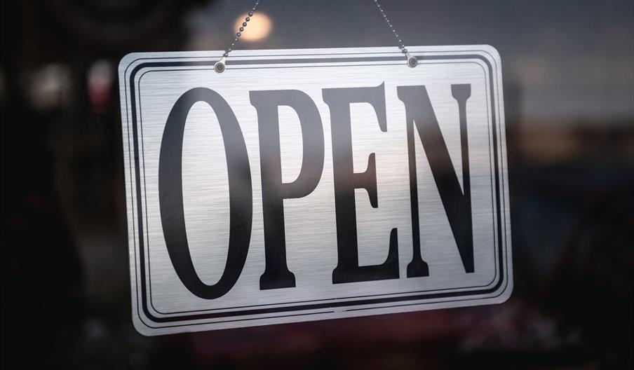Silver open sign in glass door