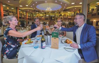 Two couples enjoy dinner together in the Garden Restaurant at Potters Resorts Hopton-on-Sea