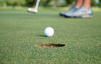 Golf ball being putted