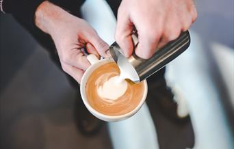 Milk being poured into cup to make latte