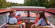 Family exploring the Broads National Park in a Day Boat