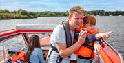 Young girl on a Day Boat spotting wildlife on the Broads National Park