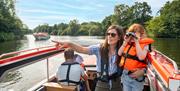 Young girl with binoculars on a Day Boat exploring the Broads National Park