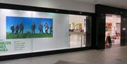 PRIMEYARC exterior shot showing left had window displaying large photograph of 7 people standing on a grassy bank with blue sky behind them