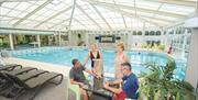 Two couples relax poolside in Palms Health & Fitness, at Potters Resorts Hopton-on-Sea