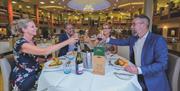 Two couples enjoy dinner together in the Garden Restaurant at Potters Resorts Hopton-on-Sea