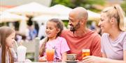 A family enjoy refreshing drinks on The South Terrace at Potters Resorts Hopton-on-Sea