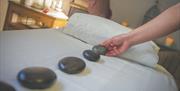 Hot Stone Massage Therapy is available at Aphrodite Beauty Studio