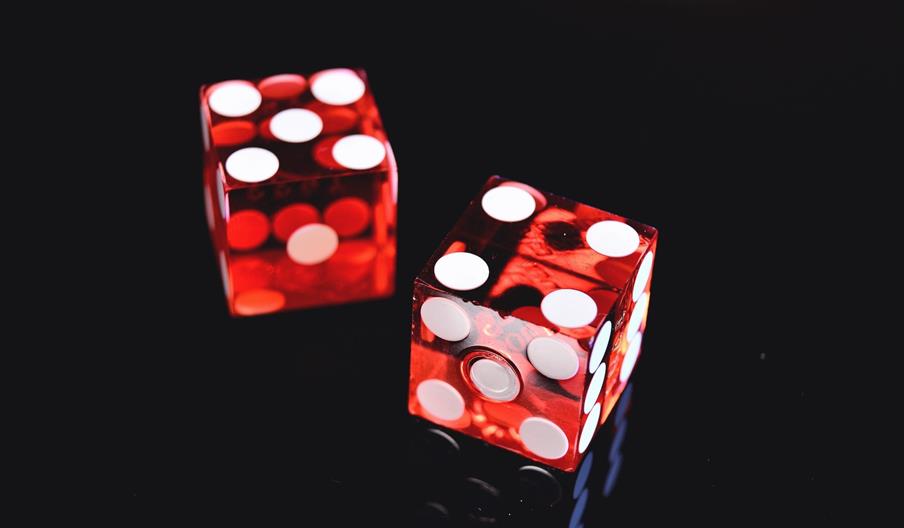 Two red dice with white spots on black background