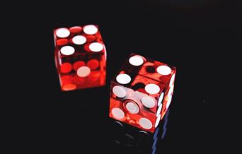 Two red dice with white spots on black background