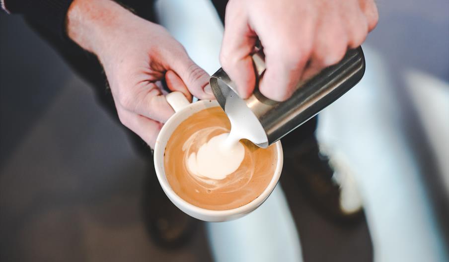 Milk being poured into cup to make latte